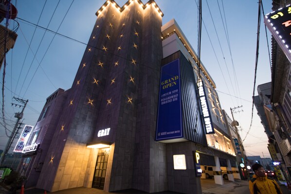 A hotel with a prominent 'GRAND OPEN' sign, a modern facade, and a 'GRAY' sign indicating the hotel name. - Gray Boutique hotel (Tongyeong)