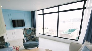 A modern living room with a sofa, armchair, and coffee table. - Gray Boutique hotel (Tongyeong)