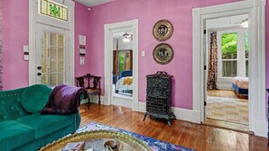 A room with a green sofa, a patterned rug, and a decorative tray with items. - Walk to Bathhouse Row! Queen Anne Victorian Cottage (Hot Springs)