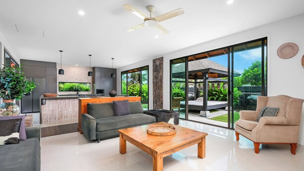 A modern living room with a sofa, coffee table, and a view of the outdoor garden. - Tranquil Beach Side Retreat - Inquire 4 Long Stay Discounts (Mount Coolum)