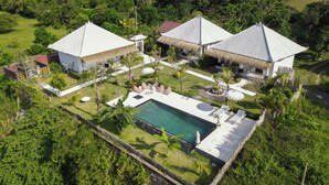 Ein Resort mit mehreren Gebäuden, einem Swimmingpool und üppiger Bepflanzung.