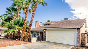 A single-story house with a garage, surrounded by palm trees. - Night at the Roxford 4b 3ba Pool (Las Vegas)