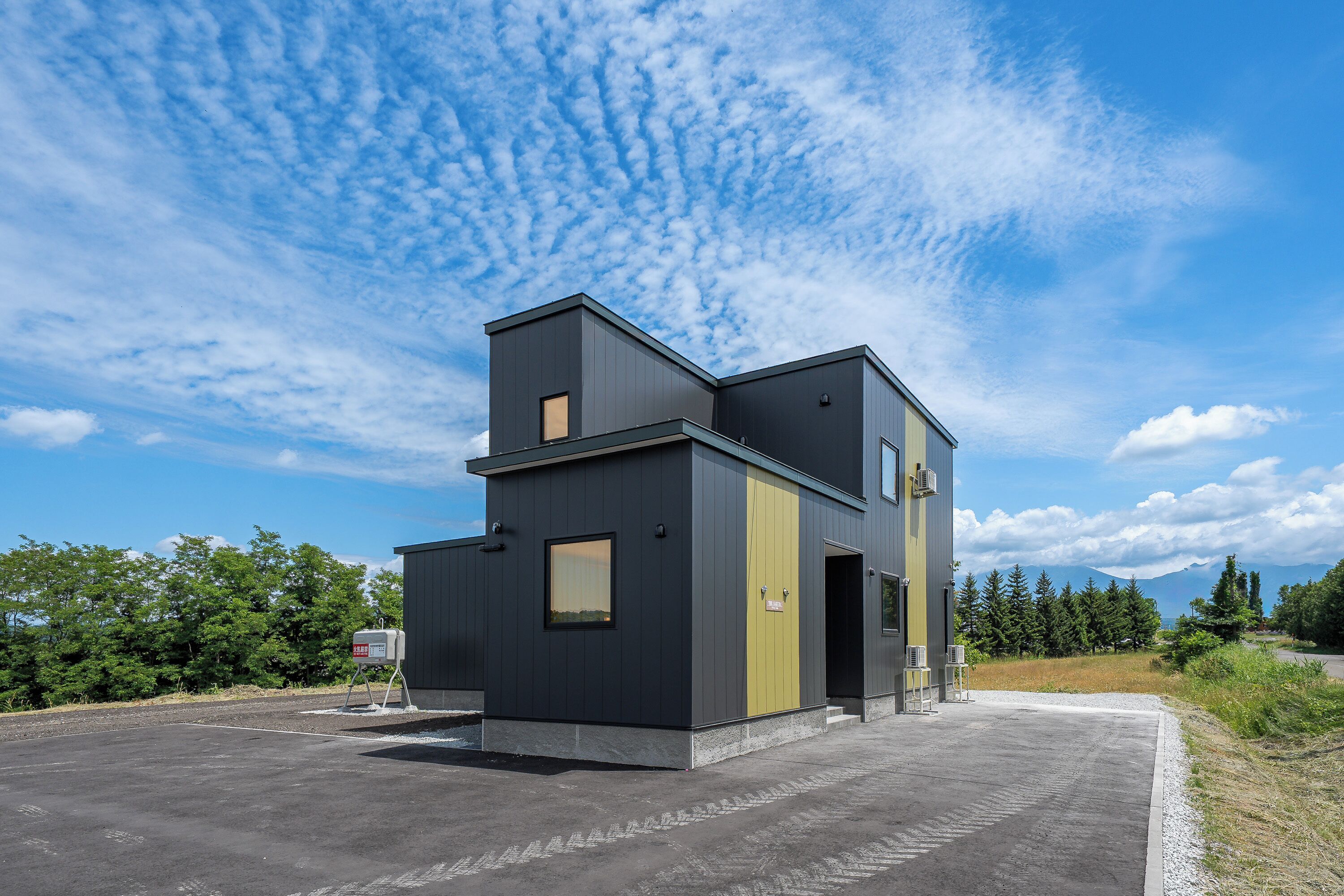 A modern two-story building with a flat roof and a large entrance.