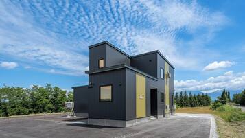 A modern two-story building with a flat roof and a large entrance.