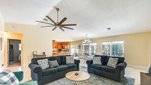 A spacious living room with two sofas, a coffee table, and a ceiling fan. - Hot Tub & Outdoor Pool: Bonita Springs Getaway! (Bonita Springs)