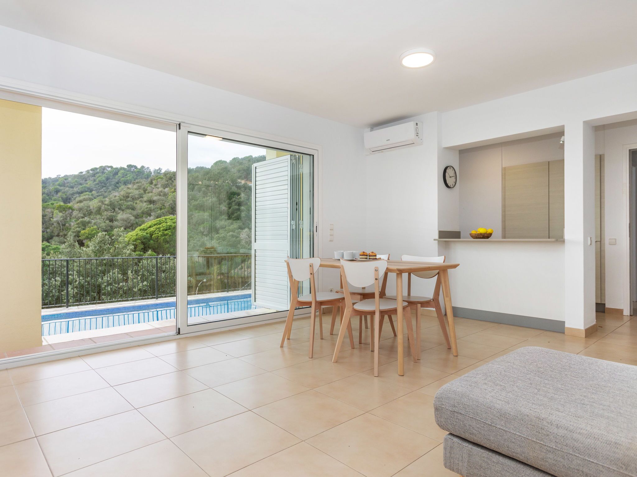 A modern apartment with a balcony, a dining area, and a kitchen.
