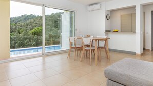 A modern apartment with a balcony, a dining area, and a kitchen.