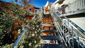 A narrow staircase with metal railings, surrounded by buildings and flowering plants. - Casa Zivula: A welcoming apartment situated at a short distance from the waterfront, with Free WI-FI. (Olbia)