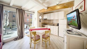 A compact kitchen with white cabinets, a wooden ceiling, and a dining area with a table and chairs. - Casa Zivula: A welcoming apartment situated at a short distance from the waterfront, with Free WI-FI. (Olbia)