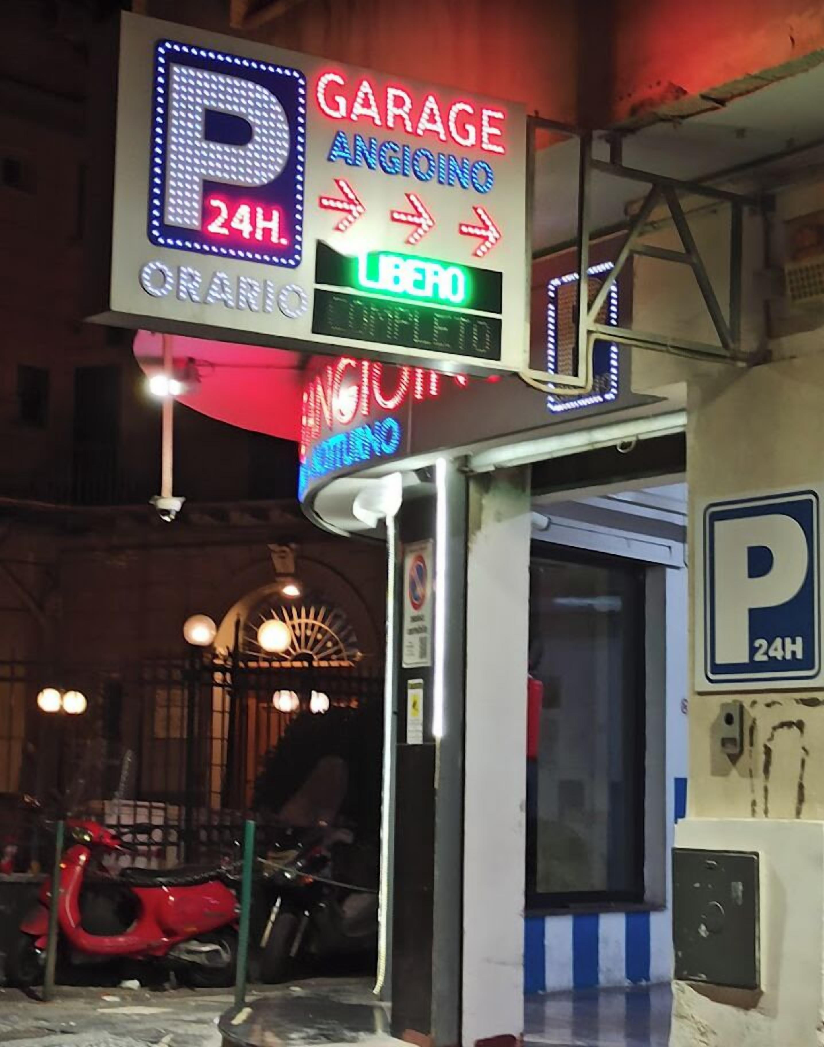 A parking garage sign with 24-hour availability and directions to the garage.