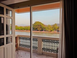 A balcony with a view of a river and trees.