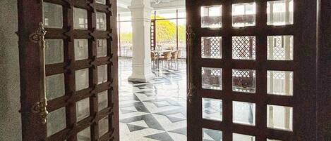 Uma entrada imponente com uma grande porta de madeira com padrão quadriculado e painéis de vidro.