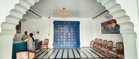 A reception area with a blue door, patterned floor, and traditional chairs.