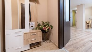 A modern bathroom with a white vanity, a mirror, a small plant, and a welcome sign. - City Central 1-Bed Apartments (Plovdiv)