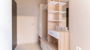 Ein modernes Badezimmer mit einem Holzschrank, einem Spiegel und einer eingebauten Ablagefläche.