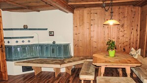 Een houten interieur met een houten bank, een tafel met een groene plant en een houten plafond.