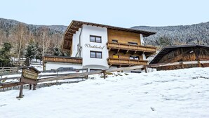 Een gebouw met twee verdiepingen, een bord met daarop 'Winklerhof' en een houten balkon.