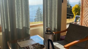 A balcony with a table, chair, and a view of the mountains.