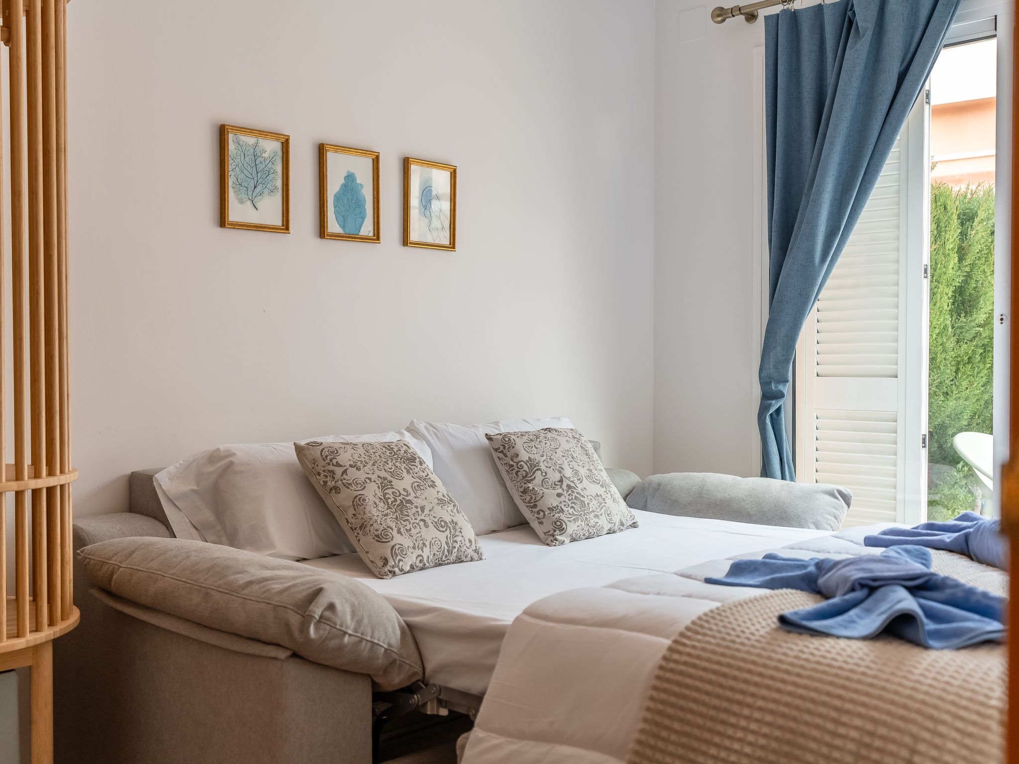 A bedroom with a bed, pillows, and a window with curtains.