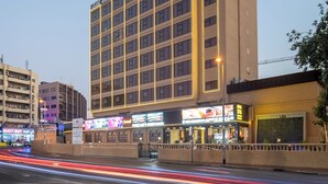 Een meerlaags hotel met een moderne gevel, meerdere balkons en een opvallende entree.