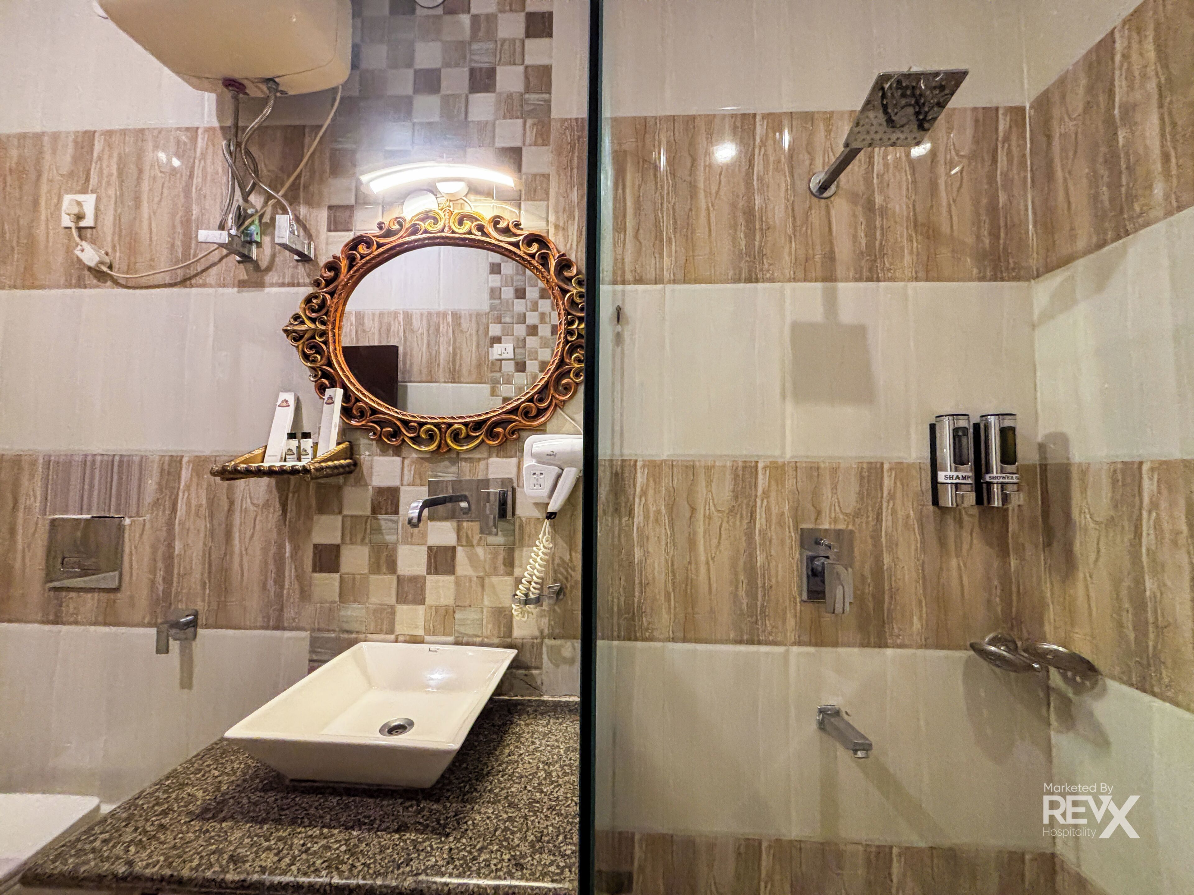 A bathroom with a large mirror, a sink, a shower, and a toilet.