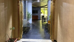 A lounge bar entrance with a sign, a potted plant, and a view into the bar area. - Ekm Hotel (Baku)