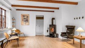 A cozy living room with wooden beams, a fireplace, a leather chair, and a table with a lamp. - "Eva" - 9km to the fjord by Interhome (Brovst)
