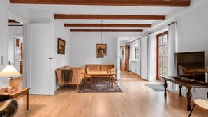A spacious living room with wooden beams, a sofa, a coffee table, and a TV. - "Eva" - 9km to the fjord by Interhome (Brovst)