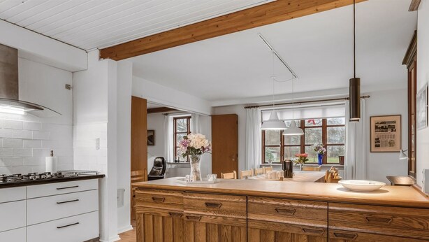 A modern kitchen with a wooden island, white cabinetry, and a large window providing natural light. - "Eva" - 9km to the fjord by Interhome (Brovst)