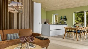 Una sala de estar moderna con un sofá, una mesa de centro y un comedor con una mesa y sillas.