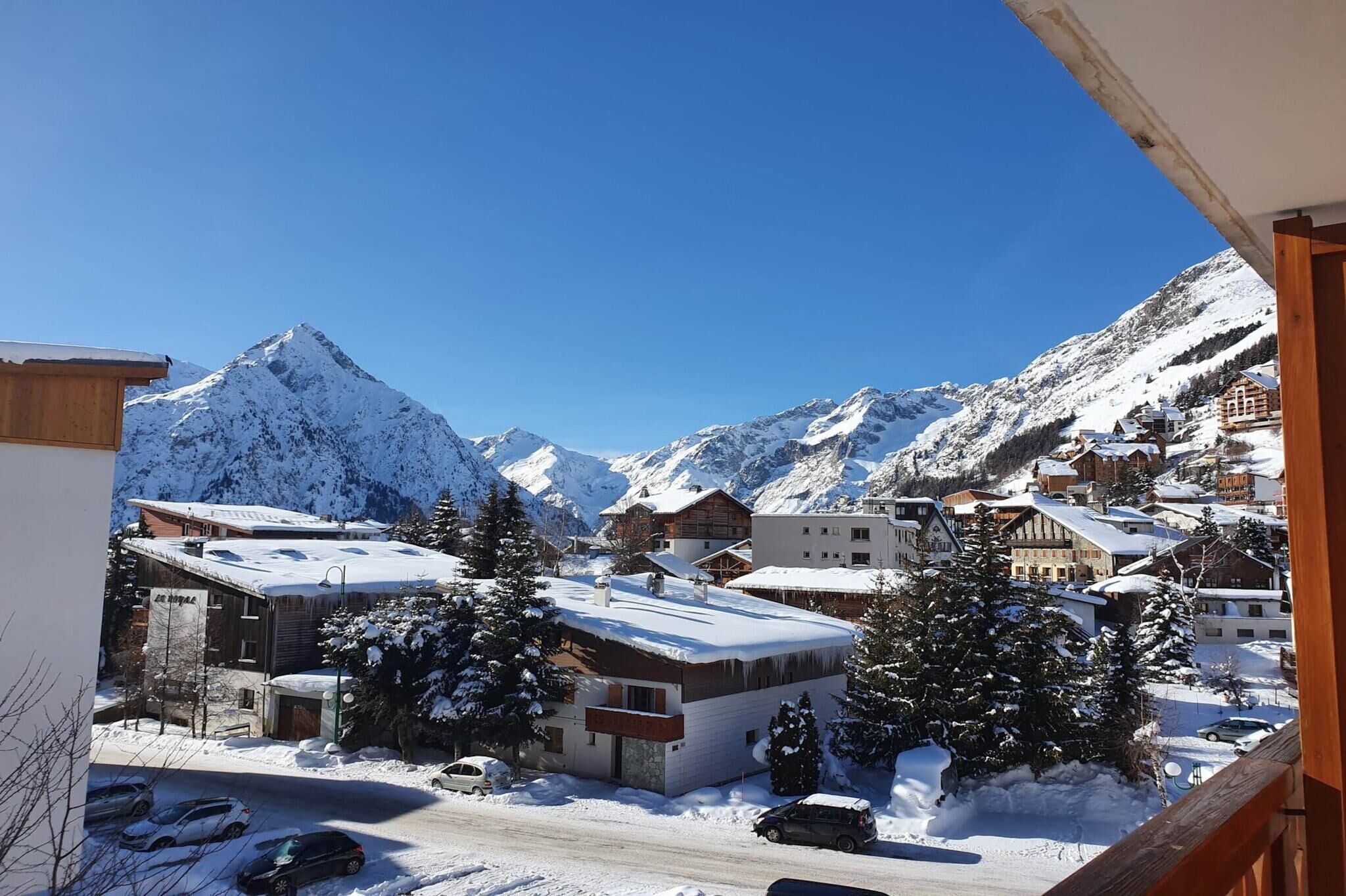 A snowy mountain town with buildings and a prominent mountain peak in the background.