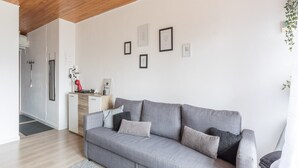 A modern living room with a grey sofa, a coffee machine, and framed pictures on the wall. - Ski-Side Stay in Orcières (Orcières)