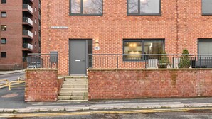 A red brick building with a grey door, a sign reading "Hurst Street," and a number "43" above the door. - Host Stay Chic Townhouse by the Docks (Liverpool)