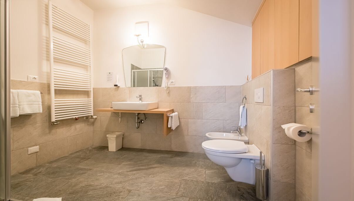 A modern bathroom with a sink, toilet, and a mirror.
