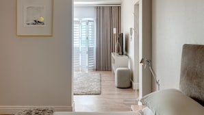 Une chambre d’hôtel moderne, équipée d’un lit, d’une table de chevet, d’une lampe et d’un tableau encadré au mur.