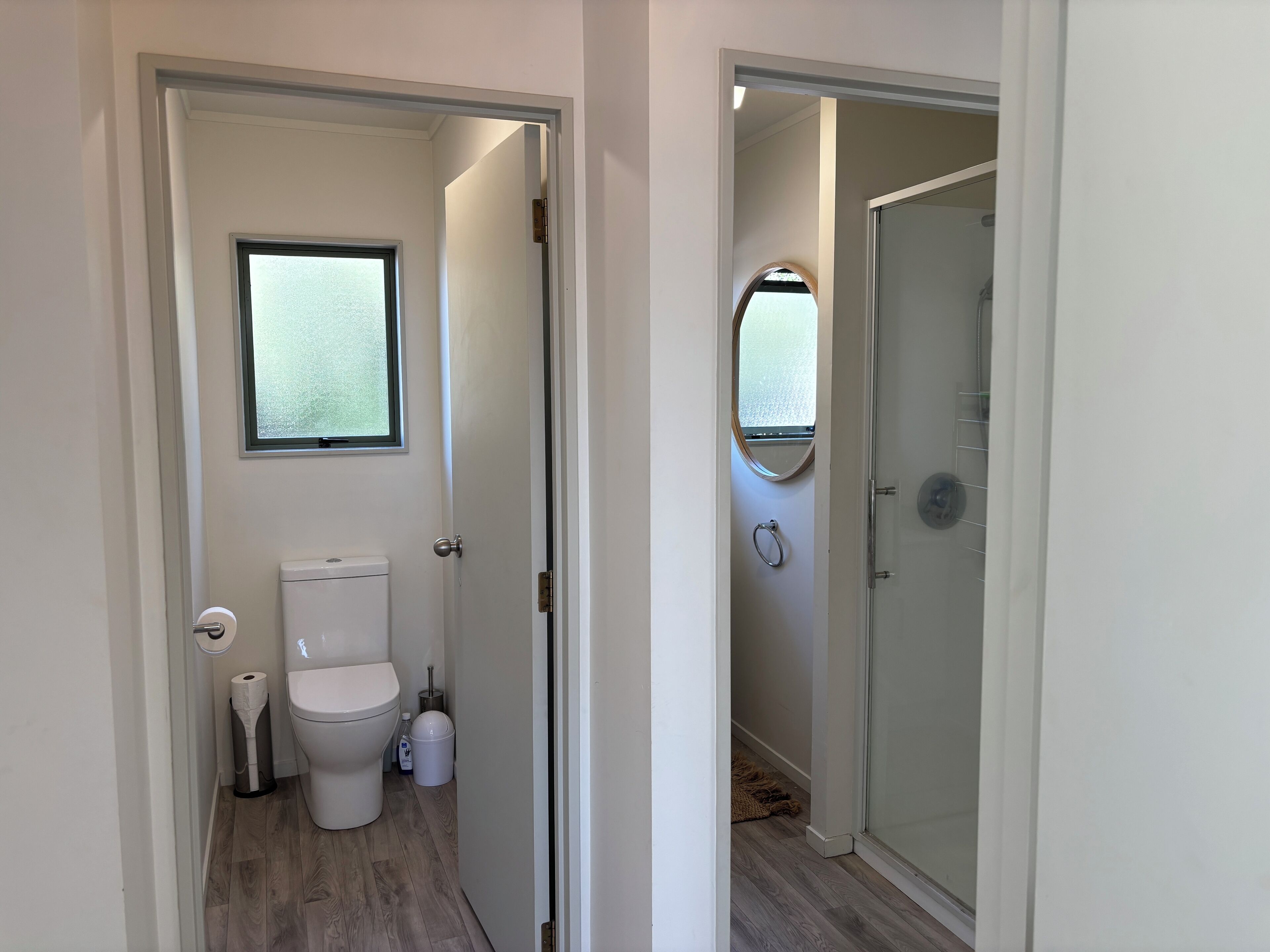 Een badkamer met toilet, raam en douche.