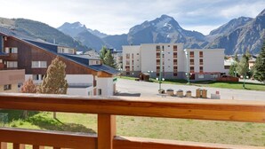 A hotel with a modern design, featuring a mix of wooden and white buildings, set against a backdrop of mountains. - Cozy Retreat with Ski Access (Les Deux Alpes)