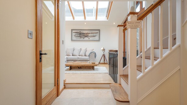 A modern interior with a staircase, a sofa, a coffee table, and a painting. - Coach House - Lovely Home in Cheltenham (Cheltenham)