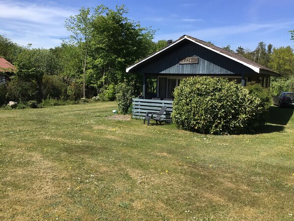 A rustic building with a sign reading 'ASCOT' in front of a well-maintained lawn and a bench. - Cottage near idyllic & peaceful sandy beach (Rønne)