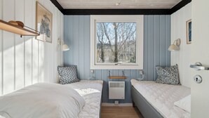 A room with two beds, a window, a radiator, and wall-mounted lamps. - Cottage near idyllic & peaceful sandy beach (Rønne)