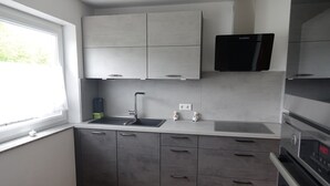 Una cocina moderna con gabinetes grises, un microondas negro y un horno empotrado.