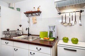 Uma cozinha com pia, torradeira, cafeteira e porta-facas.