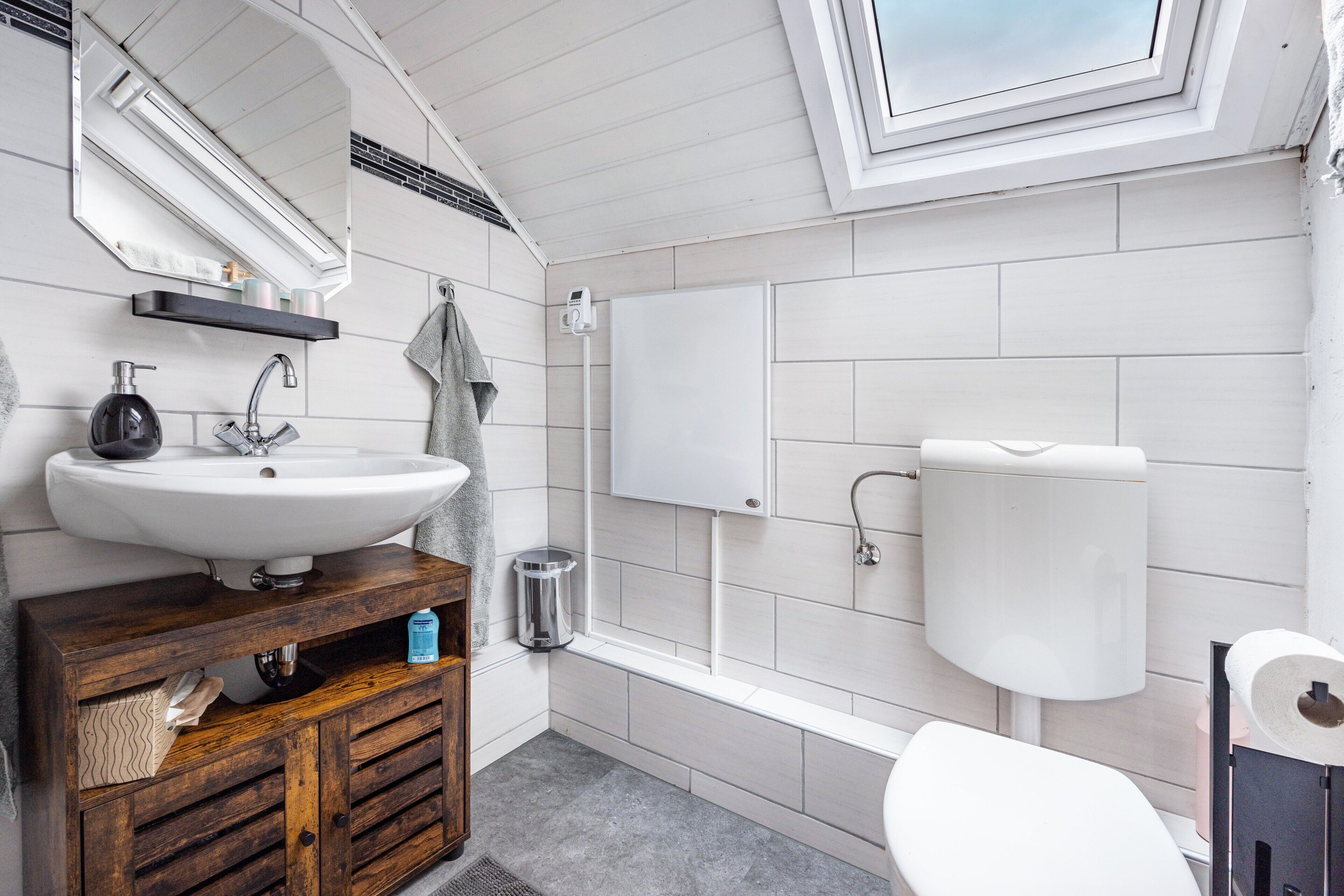 Une salle de bain moderne avec un lavabo blanc, un meuble-lavabo, des toilettes et une baignoire.