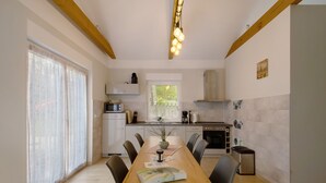 Uma cozinha moderna com mesa de jantar, cadeiras e uma janela com cortinas.