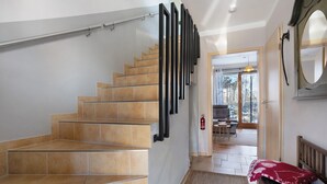 A staircase with beige tiles, a handrail, and a red cushion on a bench. - Apartment 'Spreequartier' with Lake View, private Terrace and Wi-Fi (Malschwitz)