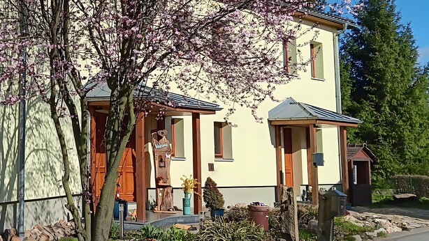 A two-story building with a porch, a mailbox, and a small garden area. - Apartment 'Spreequartier' with Lake View, private Terrace and Wi-Fi (Malschwitz)
