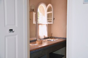 Ein Badezimmer mit Waschbecken, Spiegel und Handtuchhalter.