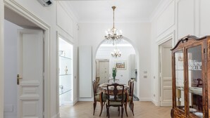 A dining area with a wooden table, chairs, and a chandelier. - View of Campo de Fiori (Roma)