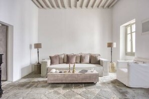 A modern living room with a beige sofa, a coffee table, and two floor lamps.
