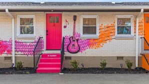 A building with a red door, two windows, and a pink guitar mural. - Barbie Dream Condo - Near Restaurants, Coffee & Bar (Nashville)